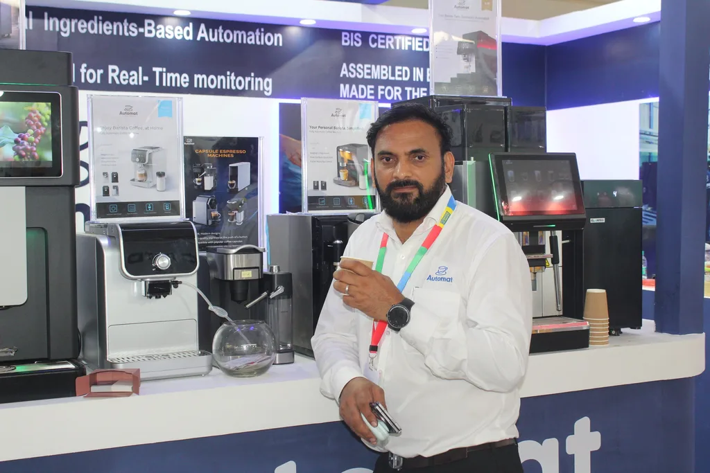 An Automat team member at the booth beside tea and coffee machines