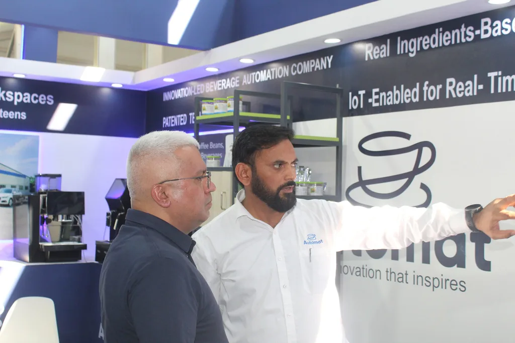 An Automat team member showing the booth to a visitor