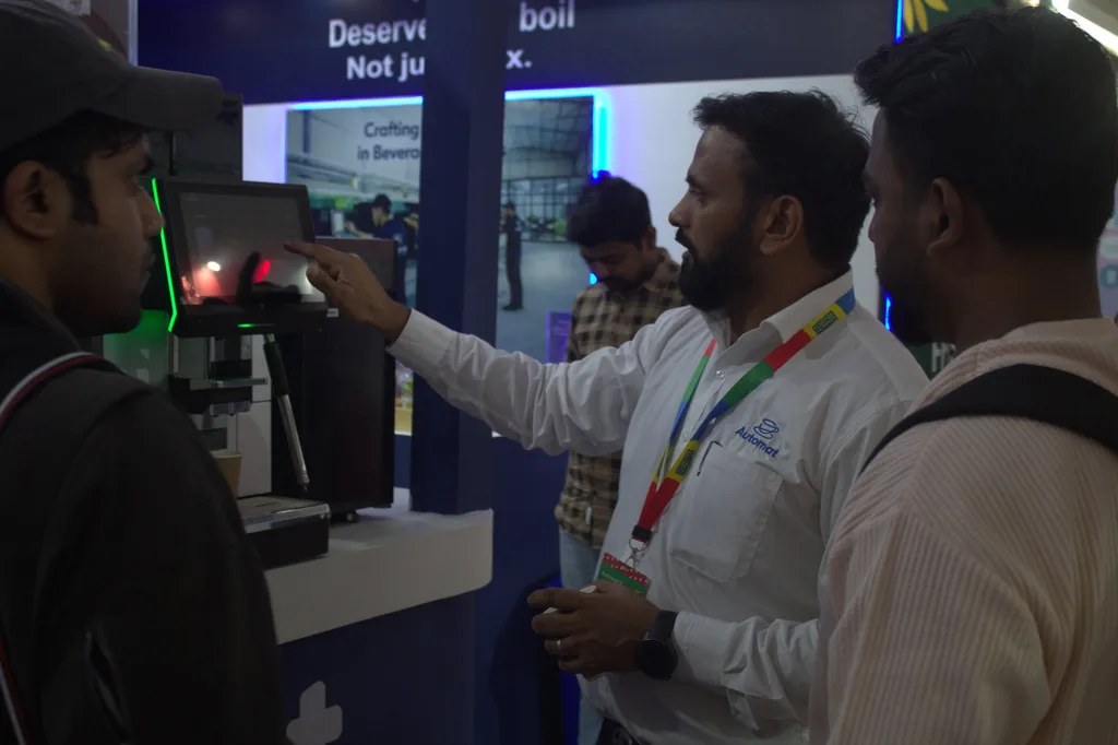An Automat team member operating a machine's touchscreen for visitors
