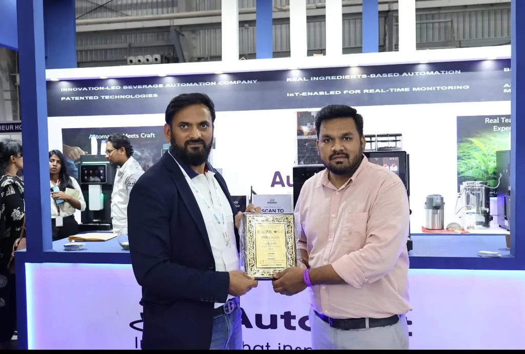 Two people holding a plaque at the Automat booth