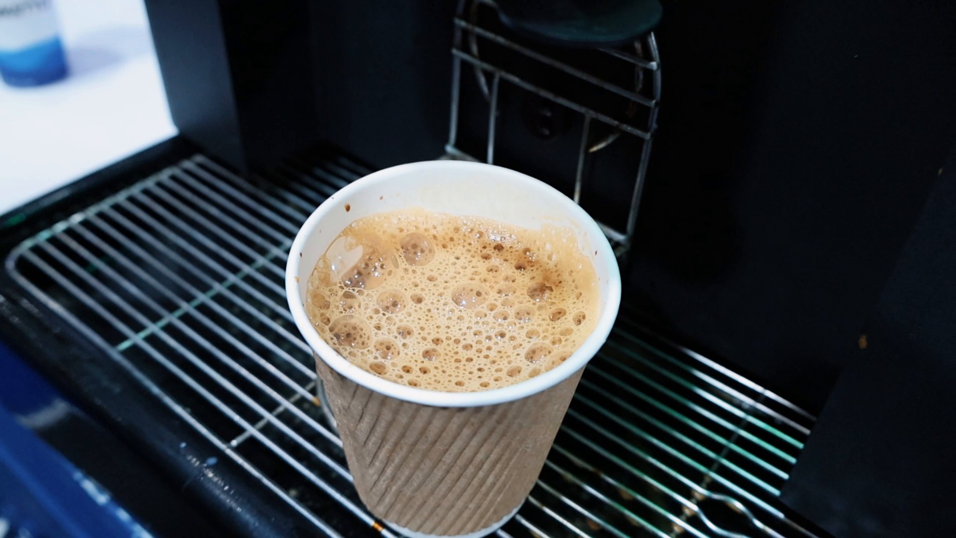 A finished cup of chai with froth on the Brewtec drip tray