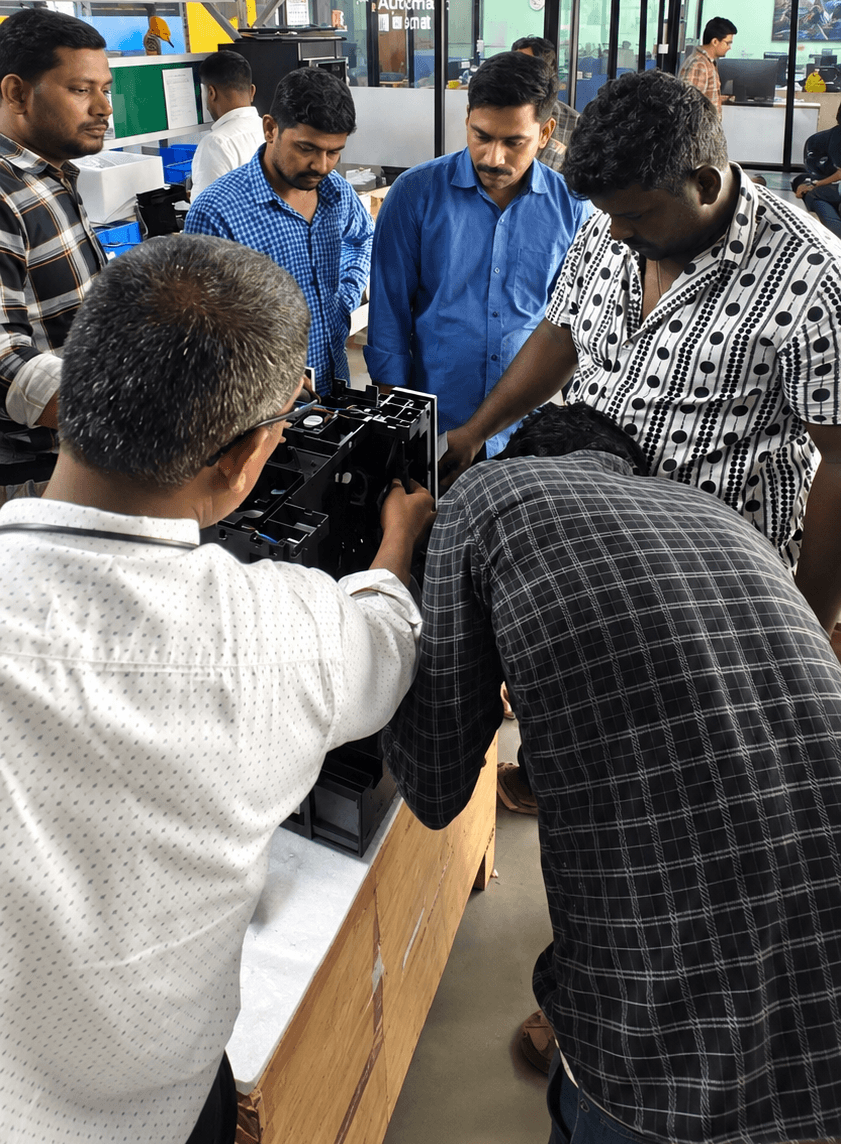 Automat team members inspecting equipment together in the workshop